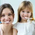 Madre e hija limpiándose los dientes